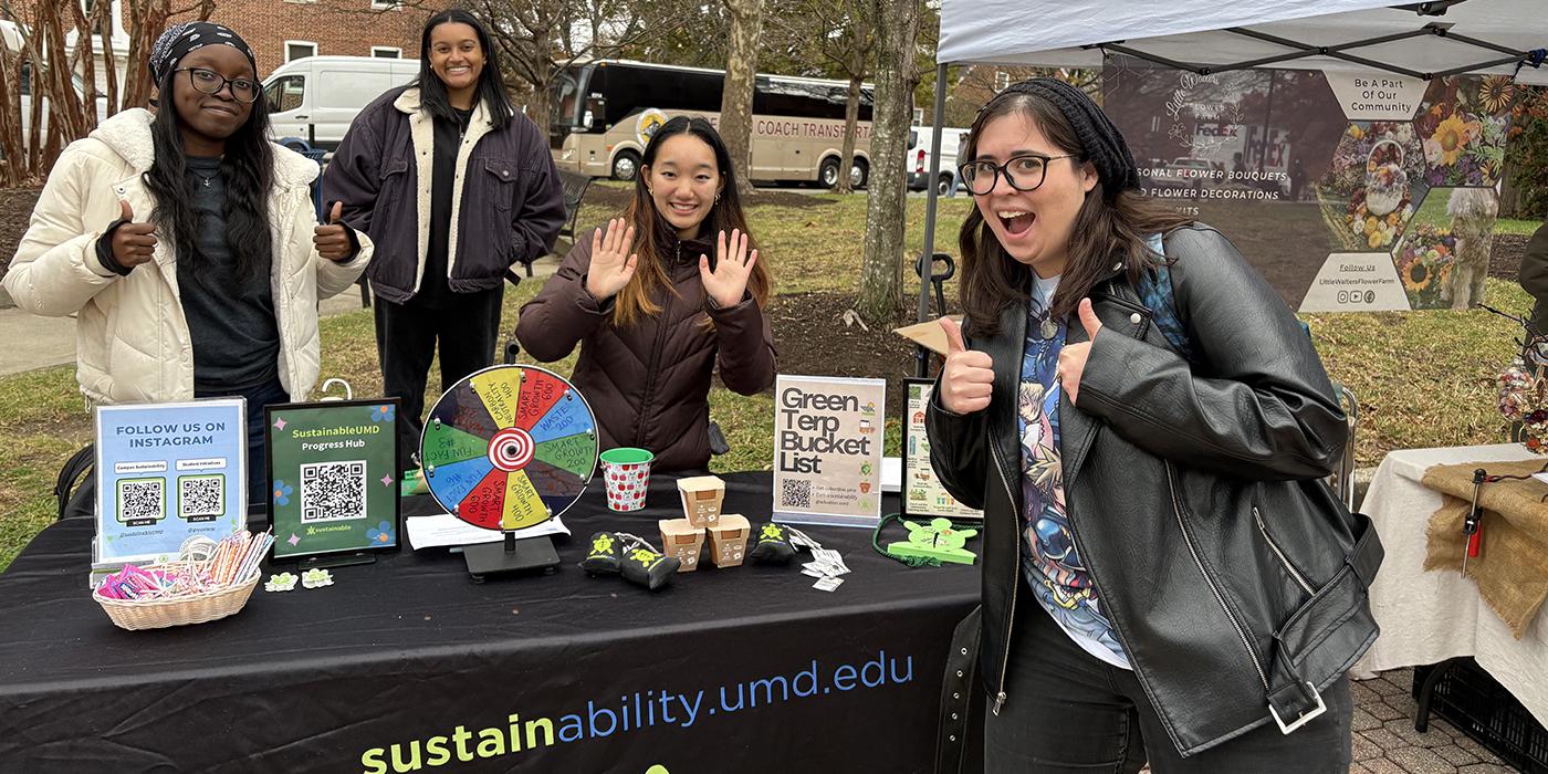 Office of Sustainability employee standing around a table for event